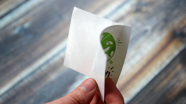 A sticker with the backing paper peeling away from it