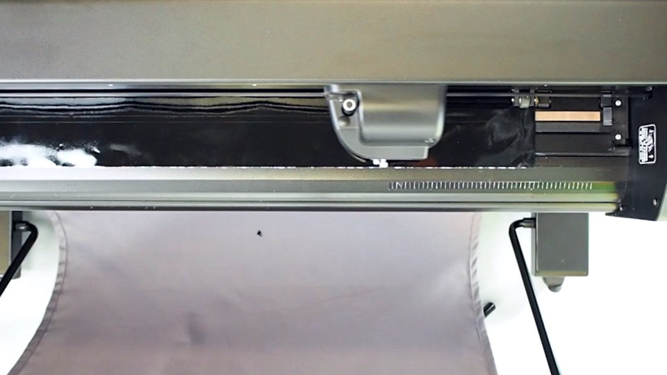 A vinyl plotter cutting a transfer sticker from black vinyl material