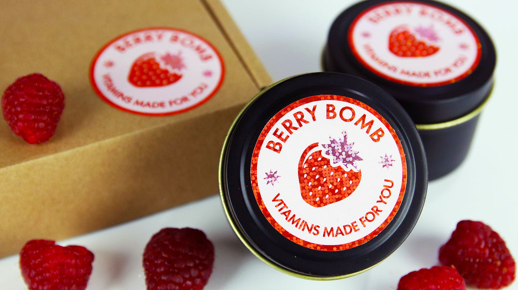 Circle glitter labels applied to black tins and a cardboard box containing a custom made vitamin mix