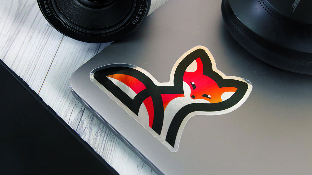 Gestanztes, spiegelsilbernes Etikett mit Fuchs-Logo-Design auf einem silbernen Laptop