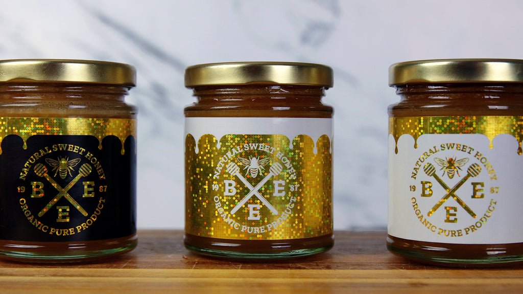Rechteckige Glitzeretiketten in verschiedenen Farben, die als Etiketten für Honiggläser verwendet werden