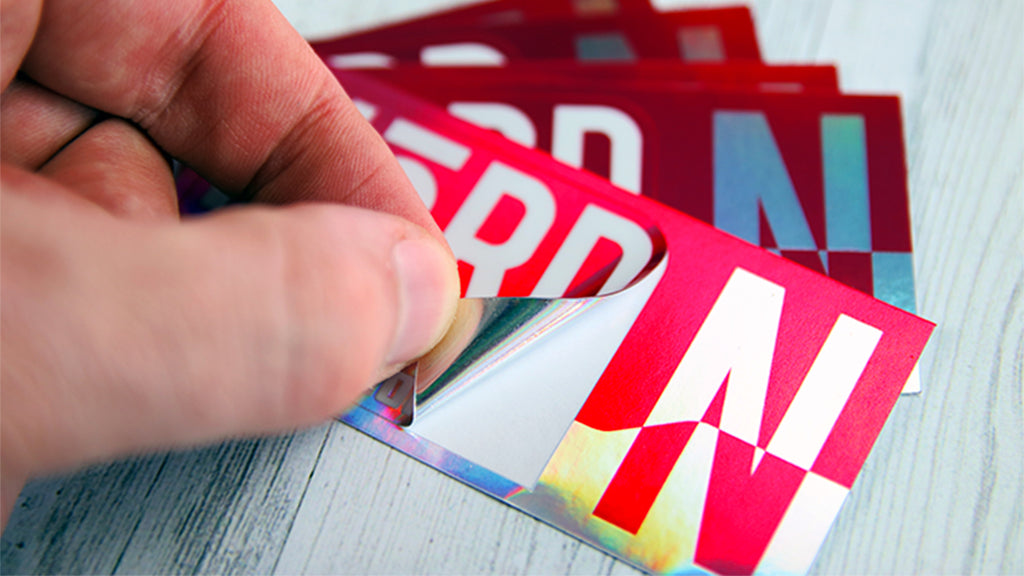 An excellent example of a custom holographic kiss cut sticker being peeled from its backing
