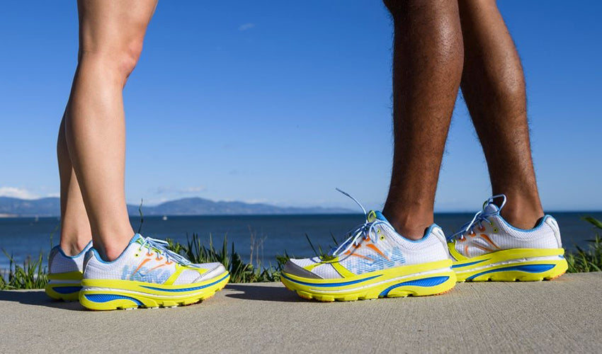 Stationary runners facing each other and wearing the same model of Hoka maximalist athletic shoes