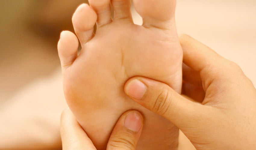 Foot care provider palpating the sole of a patient's foot