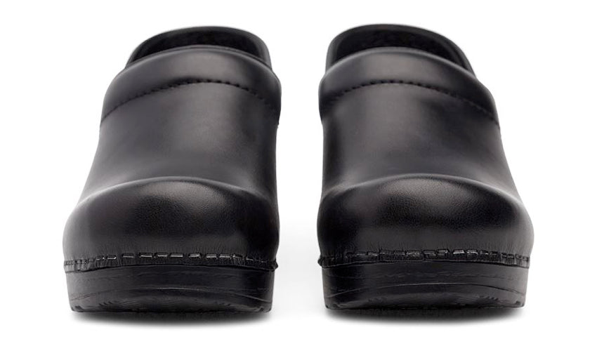 A head-on view of a pair of conventional black clogs against a white background