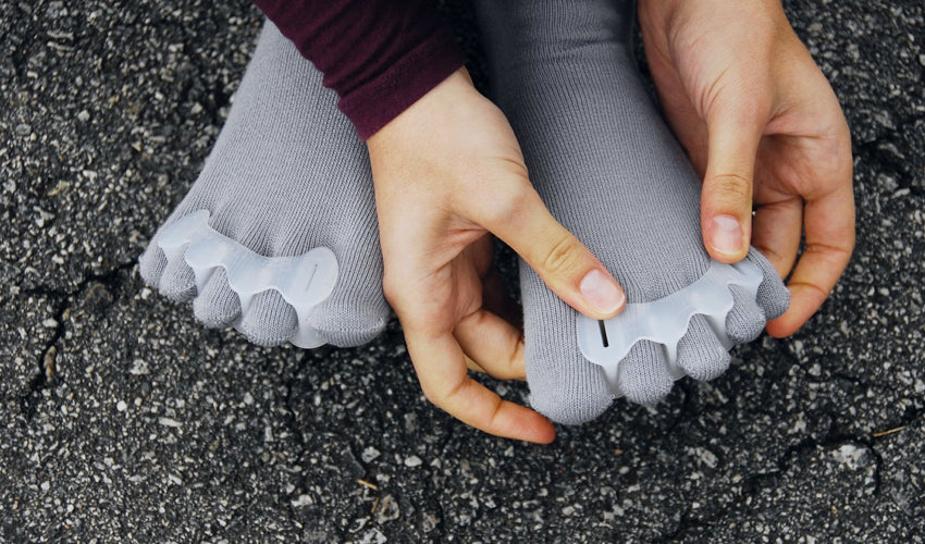 Correct Toes user applying the device while seated on pavement