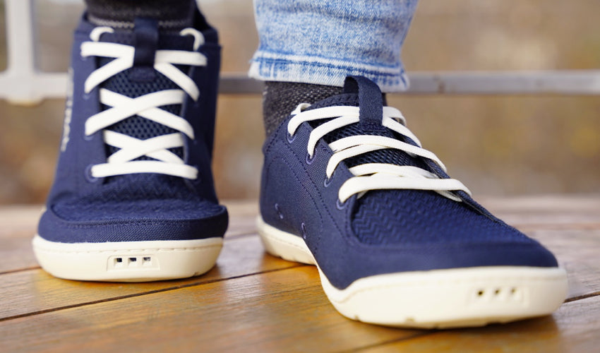 Front view of the feet of a person wearing Navy/White Astral Loyak shoes