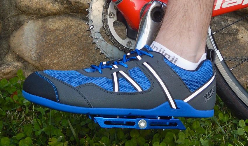 Side view of a cyclist wearing Xero Prio athletic shoes and using Blue Catalyst Pedals