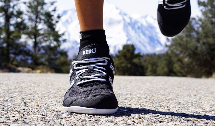 A head-on view of the toe box of a pair of Xero Prio athletic shoes worn by a road runner