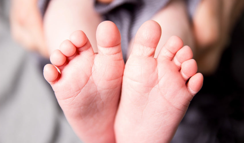 The soles of a pair of perfect baby feet with well-spaced toes