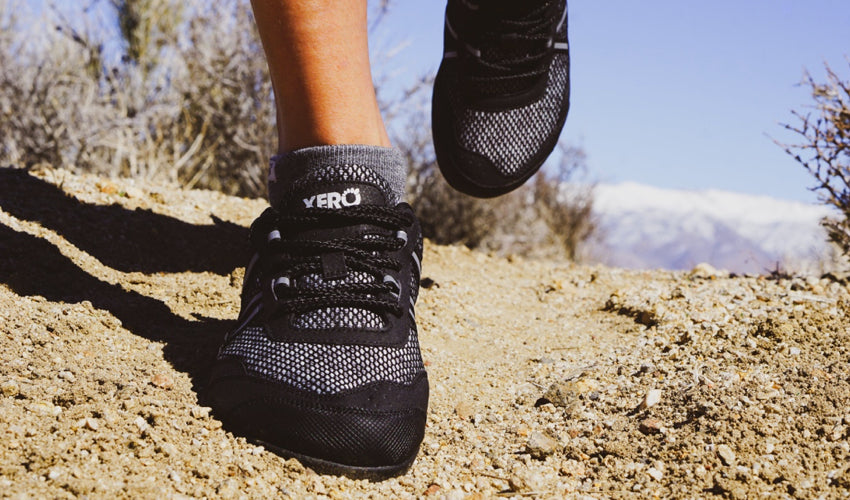 Trail runner in mid-stride wearing Xero TerraFlex Black athletic shoes