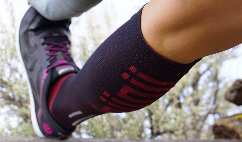 An athlete wearing Injinji compression toe socks and stretching out her hamstring