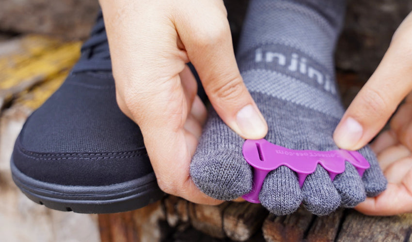 Close-up view of a Lems Chillum shoe wear putting on a Correct Toes toe spacer