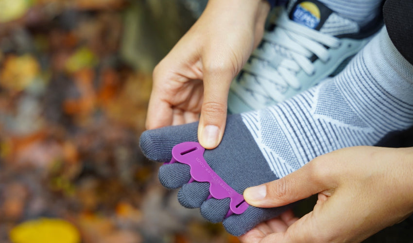 Lems Primal Pursuit wearer donning a Correct Toes Plum toe spacer over an Injinji toe sock