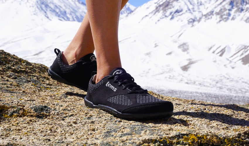 Female hiker showing off her Lems Primal 2 Black minimalist shoes