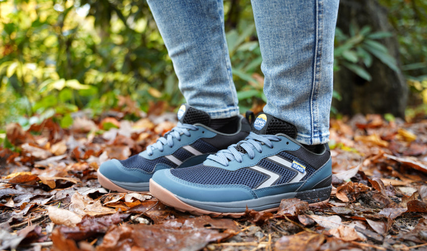 Trail walker in jeans wearing a pair of Lems Primal Pursuit shoes in Orion Blue