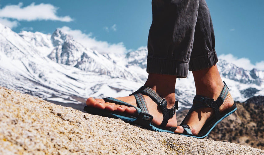 A striding hiker, in the mountains, wearing Xero Z-Trail athletic sandals