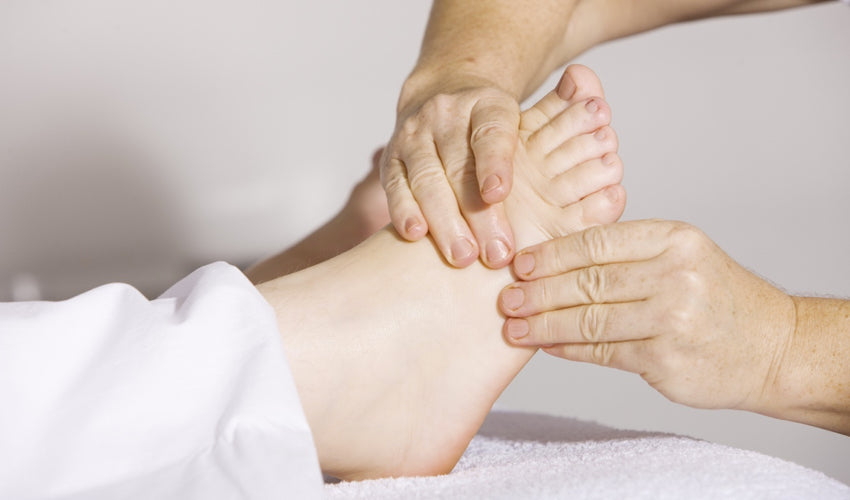 Foot care provider performing a manual treatment technique on a patient's foot