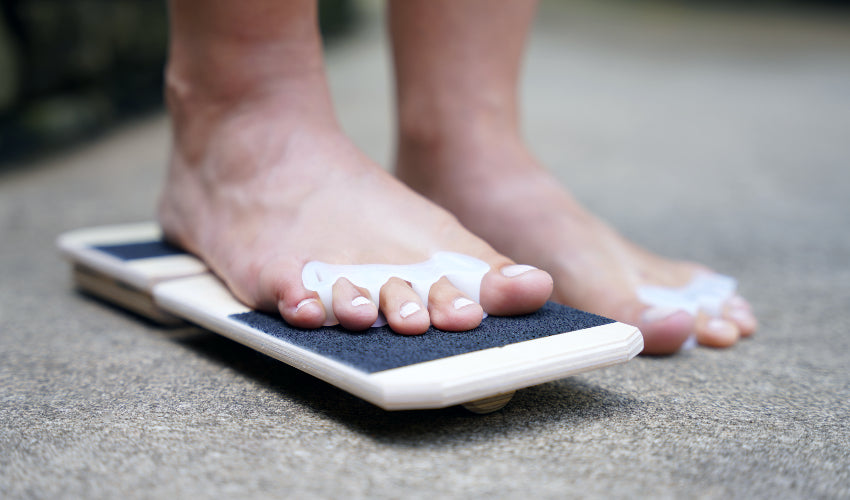 Oblique view of a bare foot wearing Correct Toes resting on a BlackBoard Basic platform