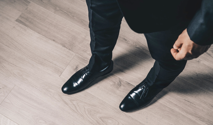 Top-down view of a pair of conventional black dress shoes with tapering toe boxes