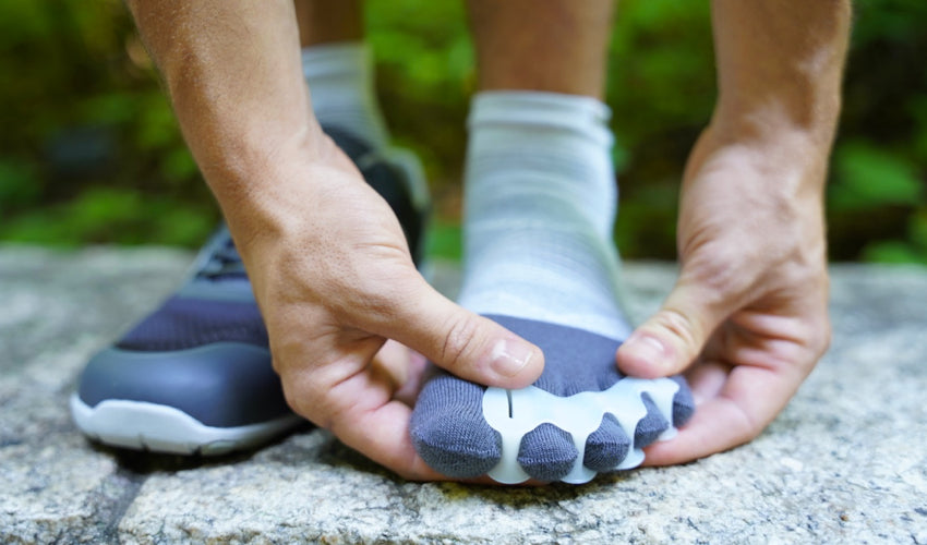 A Xero HFS shoe wearer donning a pair of Correct Toes over Injinji toe socks