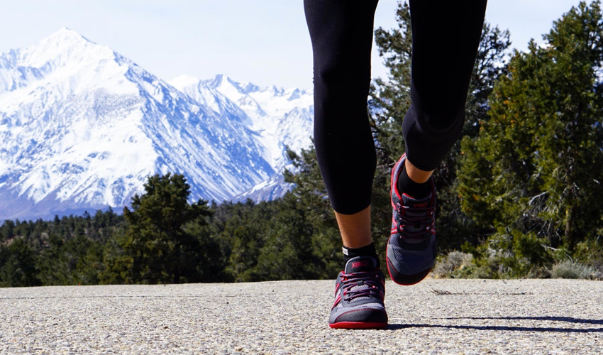 Jogger on a quiet road with snow-capped mountains in the background