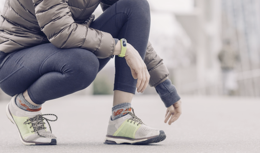 Female athlete in conventional athletic shoes and athleisure wear squatting