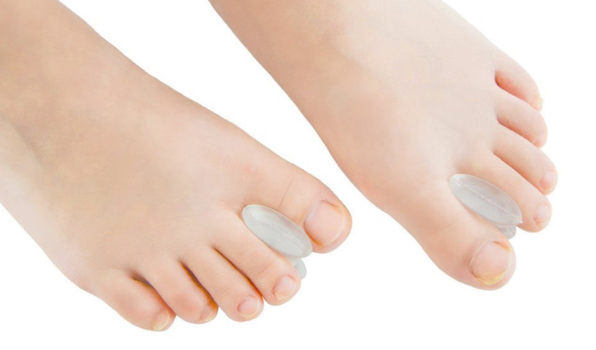 A close-up view of individual toe spacers inserted between the first and second toes