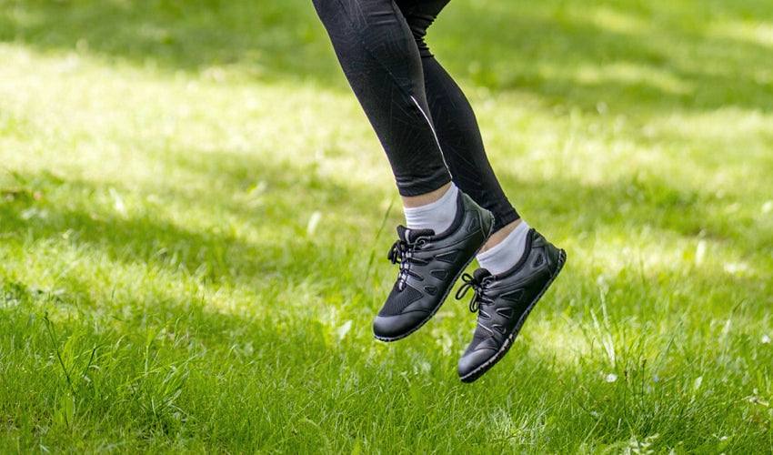 Athlete skipping through lush grass in a pair of Ahinsa Chitra running shoes