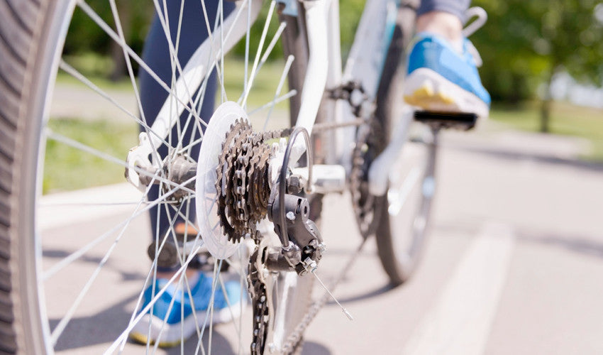 View, from behind, of a cyclist pedaling his or her bike, with an emphasis on the cassette