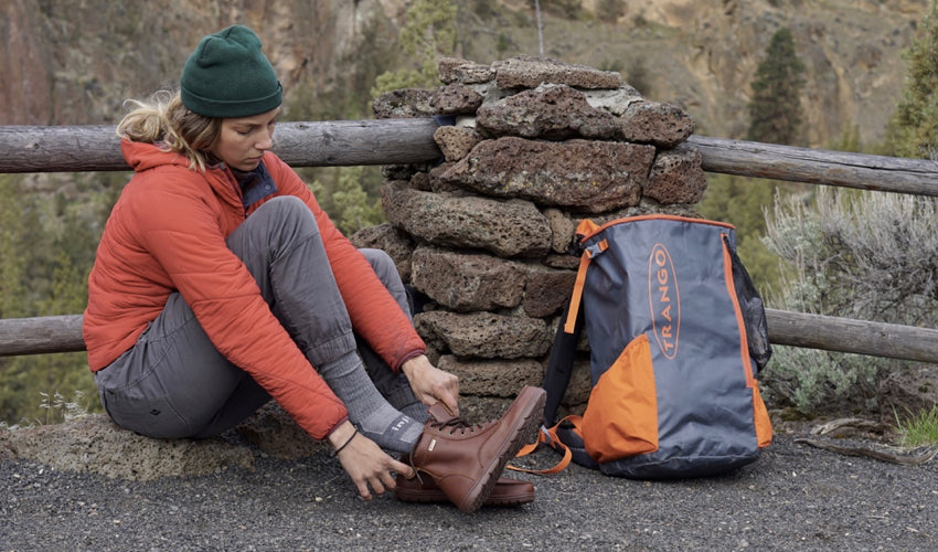 Seated hiker donning a pair of Lems Boulder Boots