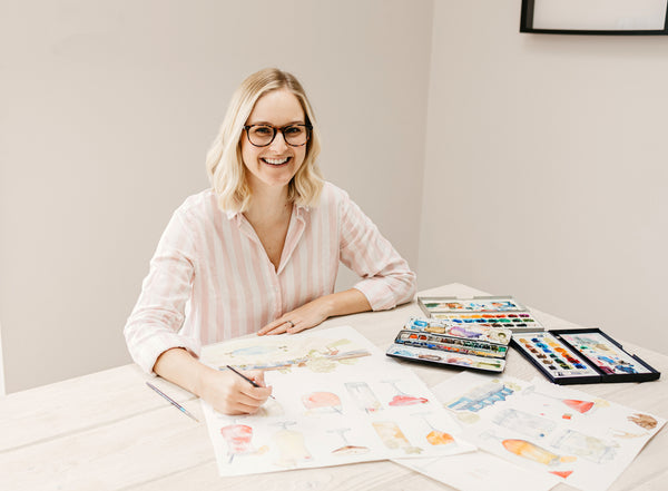 Hannah doing watercolour painting at a table