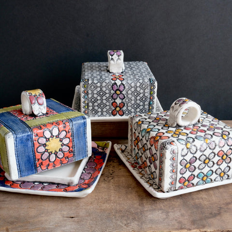 Three highly ornate and colourful square butter dishes