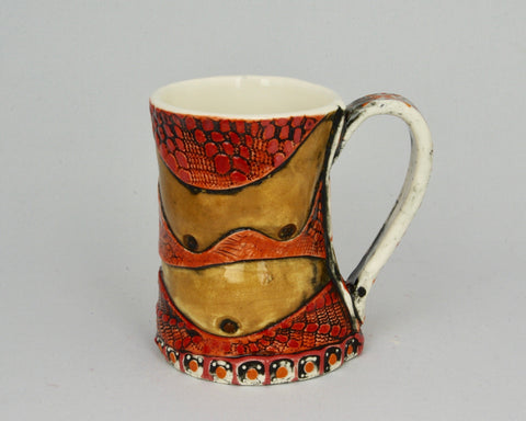 Handmade mug in red and brown with the shapes of breasts and a belly.