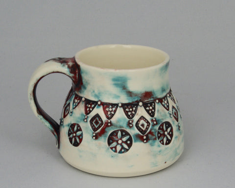 Wheel thrown wide squat mug patterned with handmade stamps.
