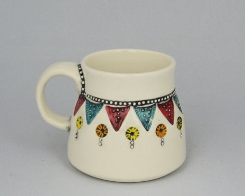 Wheel thrown mug patterned with handmade stamps.