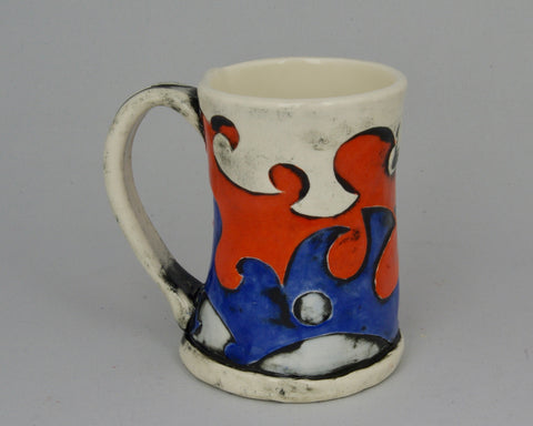 Handmade mug with layered design in blue, red and white.