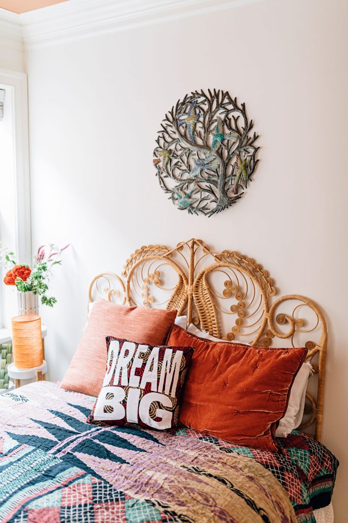 Create a space to rest in your home, especially if you work from home. Image features a bed covered in a handmade quilt from India and handmade throw pillow that says Dream Big. 
