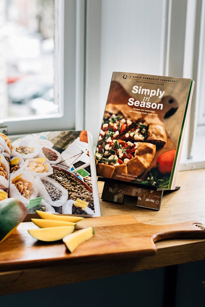 Simply in Season Cookbook in a kitchen window sill. 