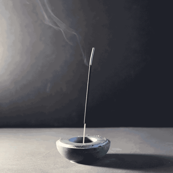A gif of agarbatti, stick incense, burning in the Stone Incense and Candleholder from Ten Thousand Villages. The smoke moves serenely upward. 