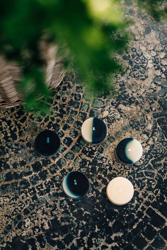 Waxing Moon Tealights featured near a fern on a mosaic tabletop. 