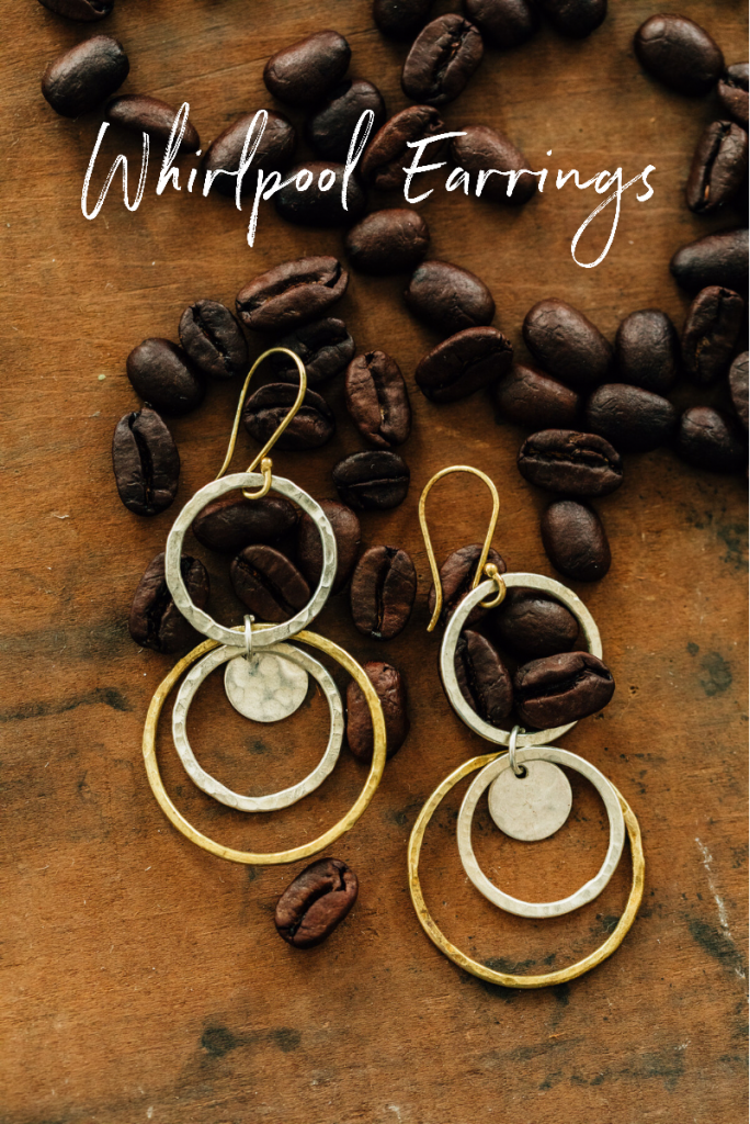 Whirlpool Earrings from Ten Thousand Villages | Handmade fair trade jewelry by artisans of Bombolulu Workshops in Kenya. Earrings lay in scattered coffee beans. 