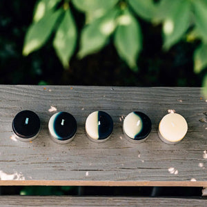 waxing and waning moon tea lights, set of five on a wood table with greens in the background