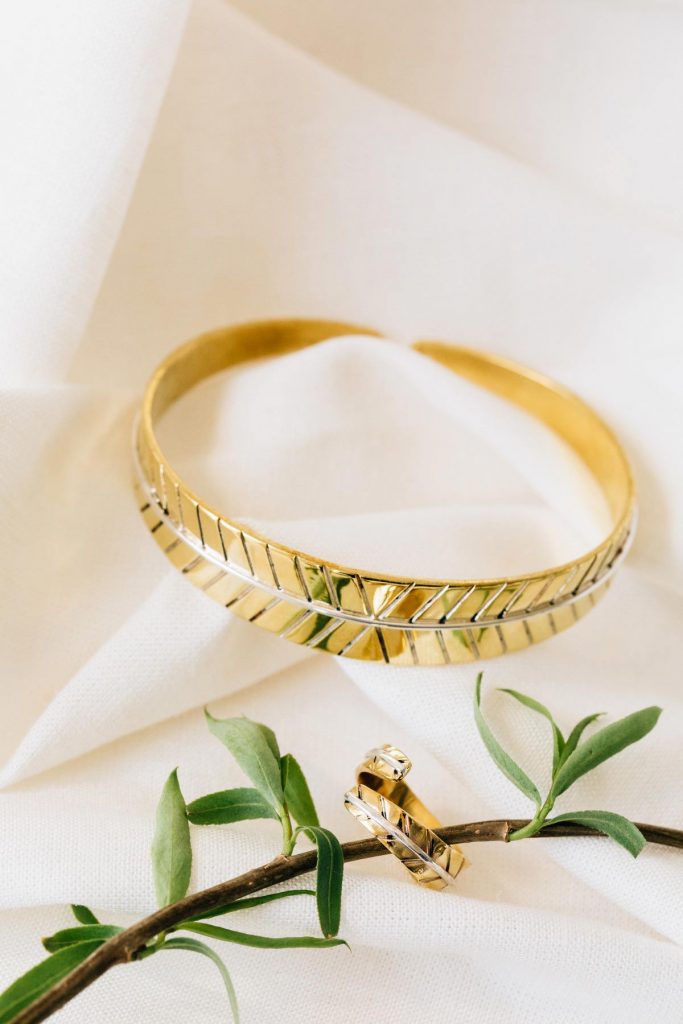 Bombshell Jewelry pieces, Leaf Ring and Leaf Cuff are pictured with an herb sprig on a white background. 