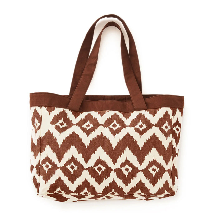 The Evolution Carryall in brown is a large carryall with shoulder straps and hand screen printed chevron design. 