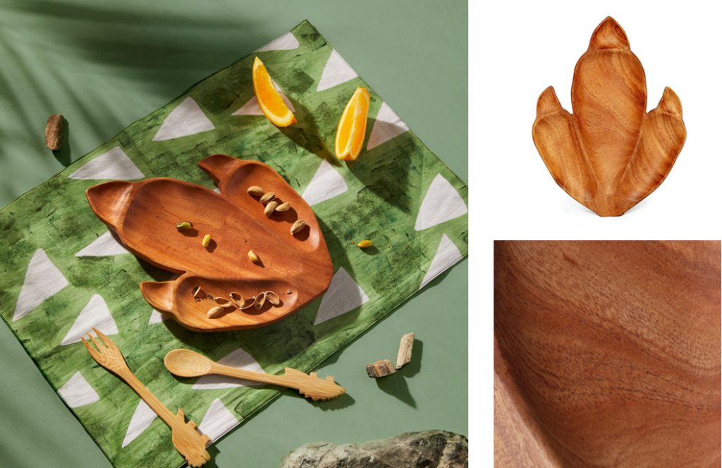 A montage of images featuring the Tyrannosaurus Rex Plate from the Jurassic World x Accompany fair trade movie merchandise collection at Ten Thousand Villages. Shown most prominently on top of the green Stegosaurus Placemat with the Ferocious Bite Flatware and orange slices. 