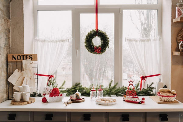 Christmas decor on a kitchen counter by a window.