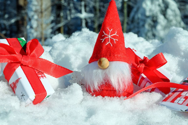 Santa gnome with gifts in snow.