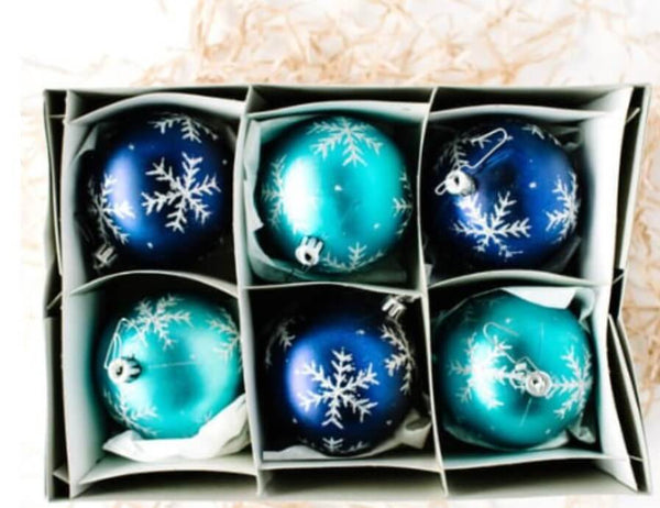 Box of blue Christmas balls with white snowflake patterns.