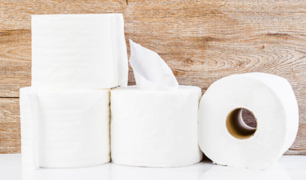 Stack of white paper tissues on a wooden background.